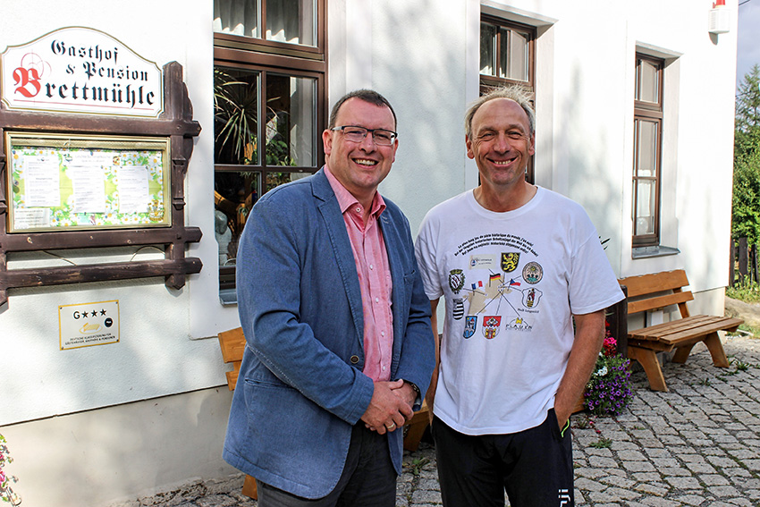 Ronny Wähner und der französische Buchautor Laurent Guillet vor der Brettmühle in Königswalde.